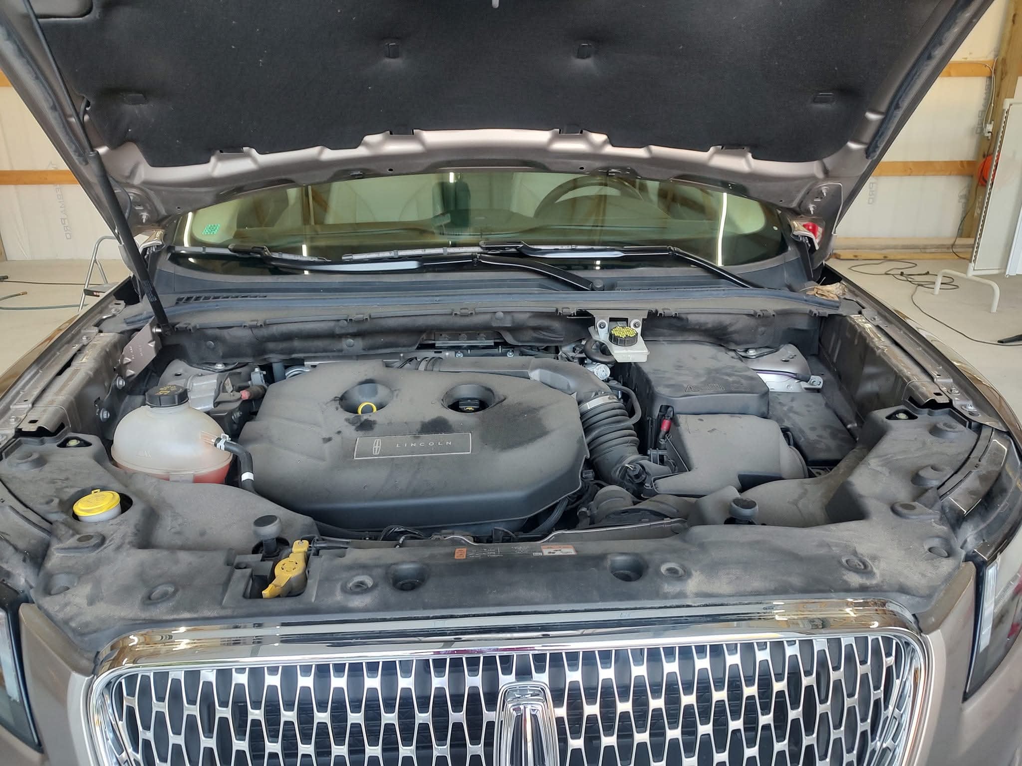 Dirty engine bay covered in grime and dust before detailing